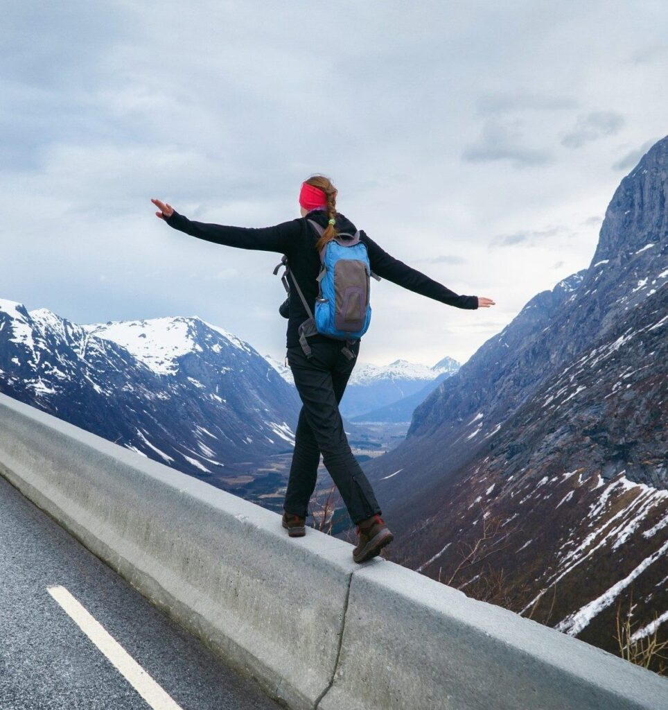 Bilde av en dame som balanserer på en vegkant